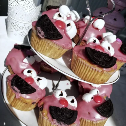 Auf einer Etagere stehen Muffins, die wie Elmo verziert sind.