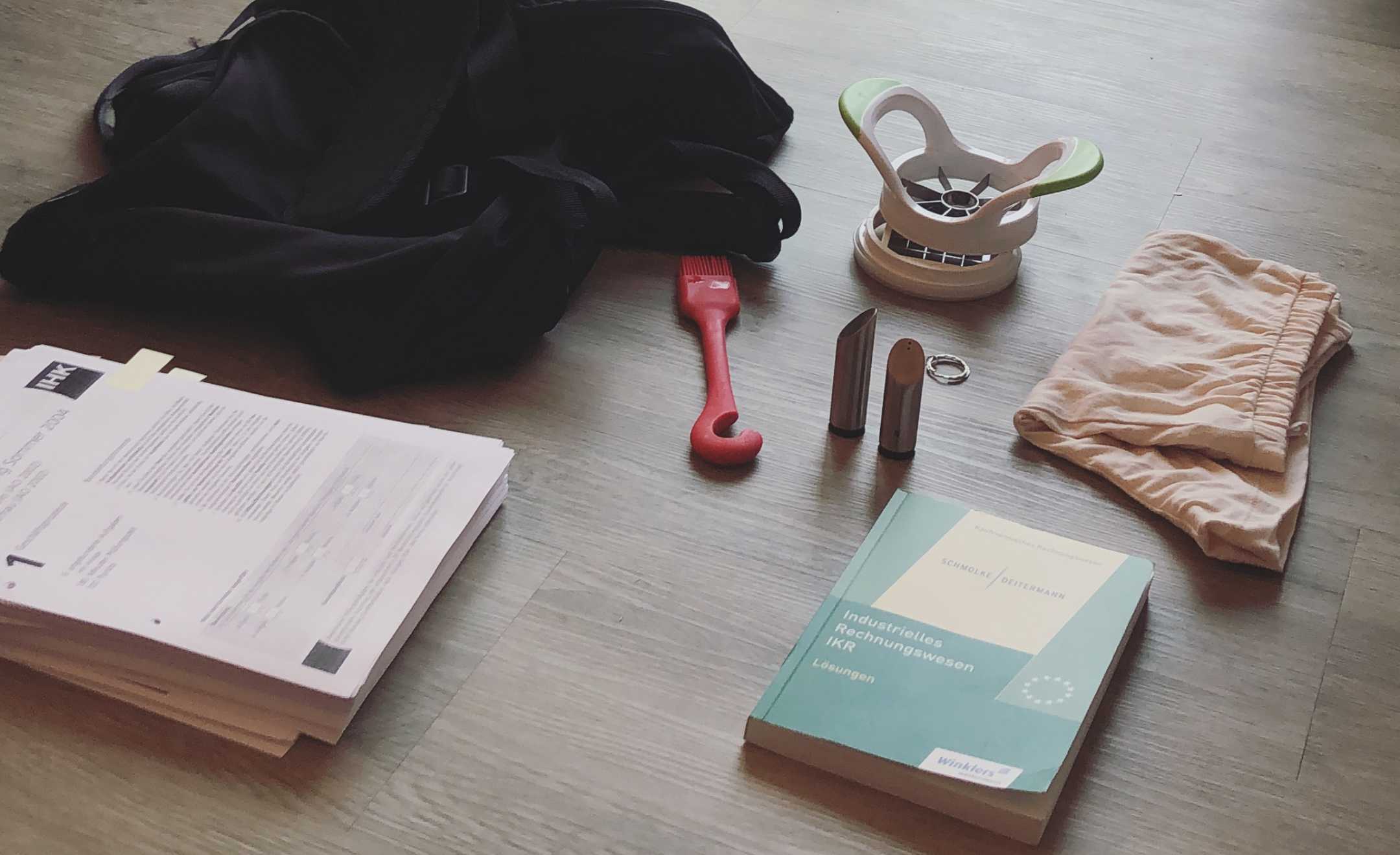 Tasche, Papiere, ein Buch und andere Kleinigkeiten die im Rahmen der Minimalismus-Challenge ausgemistet worden sind.