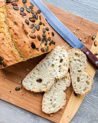 Ein aufgeschnittenes Dinkelbrot für Anfänger auf einem Holzbrett.