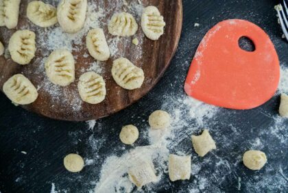 fertig geformte Gnocchi liegen auf einem Holzbrett.