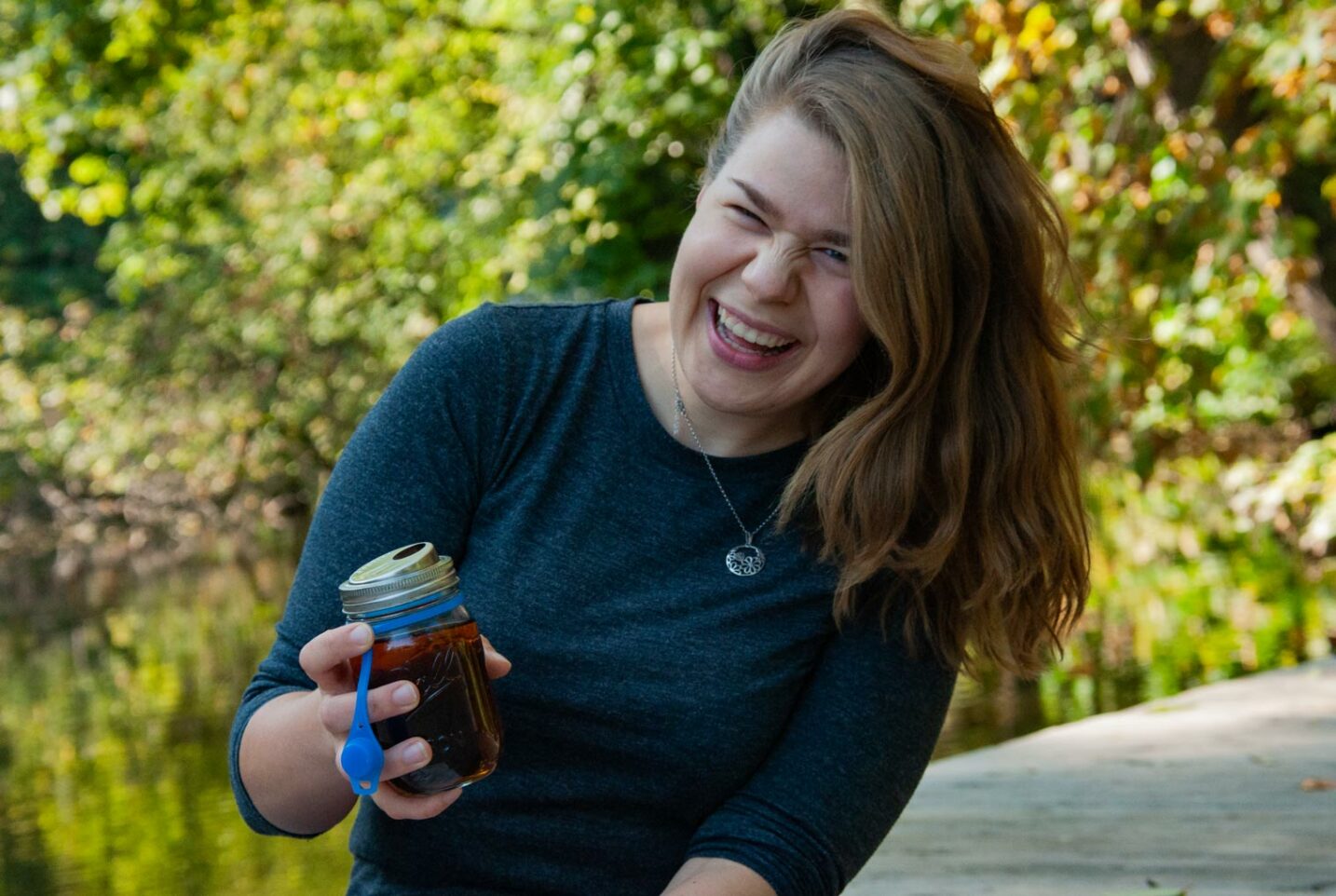 Annkathrin lacht in die Kamera und hält in der Hand einen To-Go-Becher