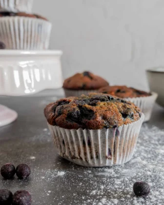 Ein Blaubeer-Muffin ist im Center des Bildes, von vorne fotografiert.