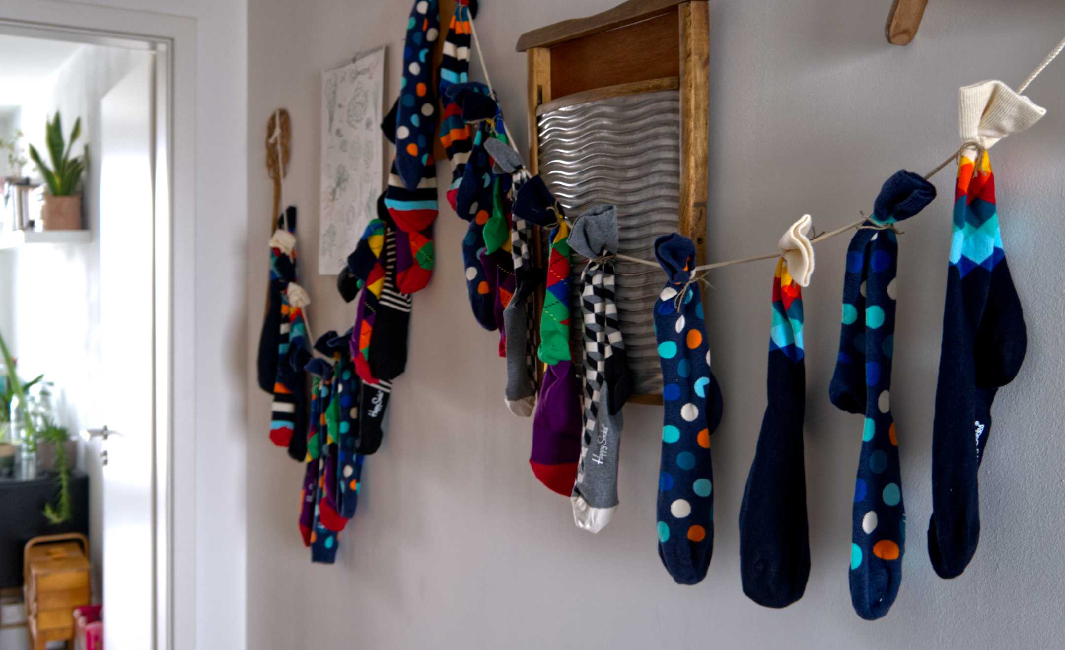 Ein Socken-Adventskalender auf einem Band an der Wand aufgehängt.