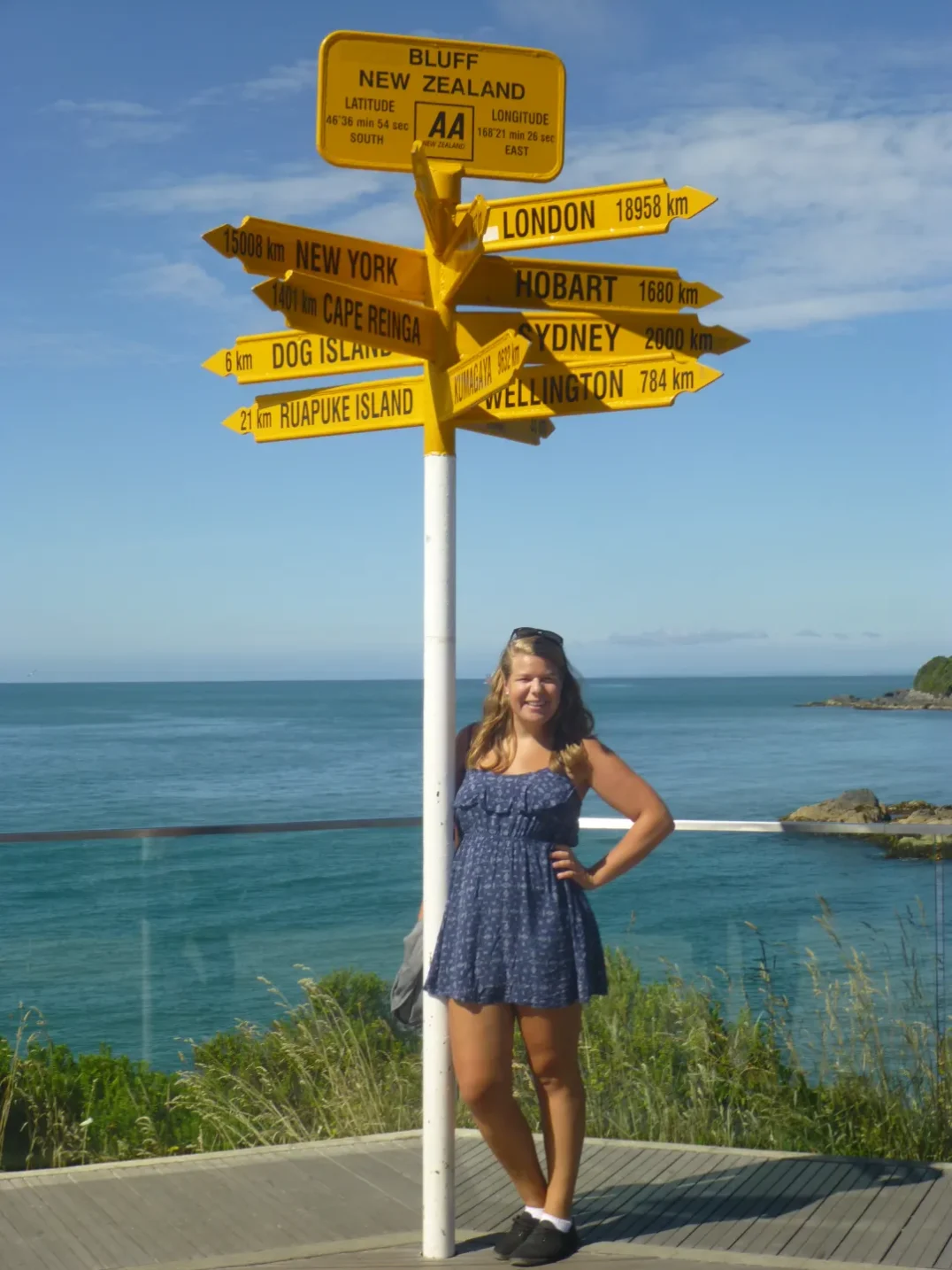 Annkathrin steht im Kleid am Stirling Point in Bluff in Neuseeland.